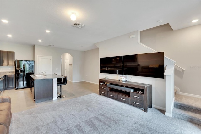 carpeted living room featuring sink