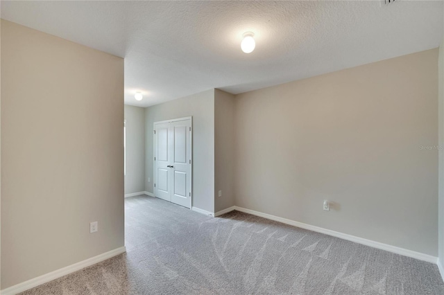 carpeted empty room with a textured ceiling