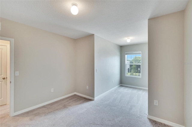 carpeted empty room with a textured ceiling