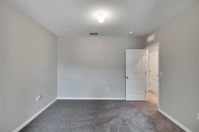 empty room with a textured ceiling and carpet flooring