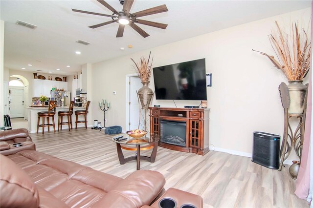 living room featuring ceiling fan and light hardwood / wood-style flooring