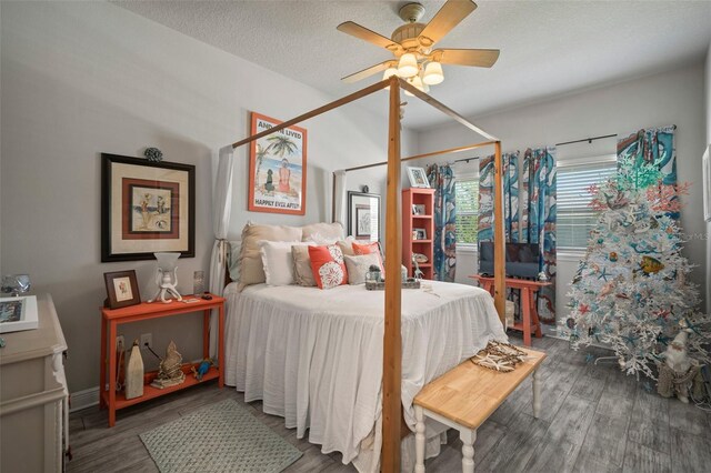 bedroom with hardwood / wood-style floors, ceiling fan, and a textured ceiling