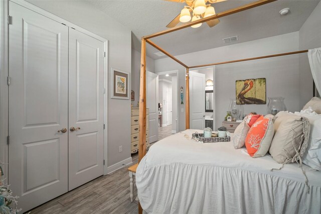 bedroom with a textured ceiling, light wood-type flooring, a closet, and ceiling fan