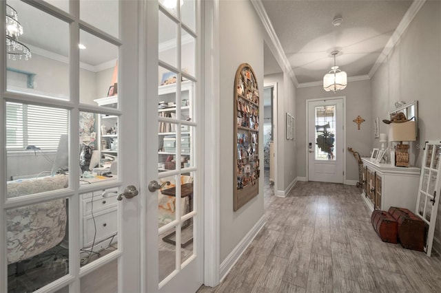 entryway with hardwood / wood-style floors, a textured ceiling, crown molding, and french doors