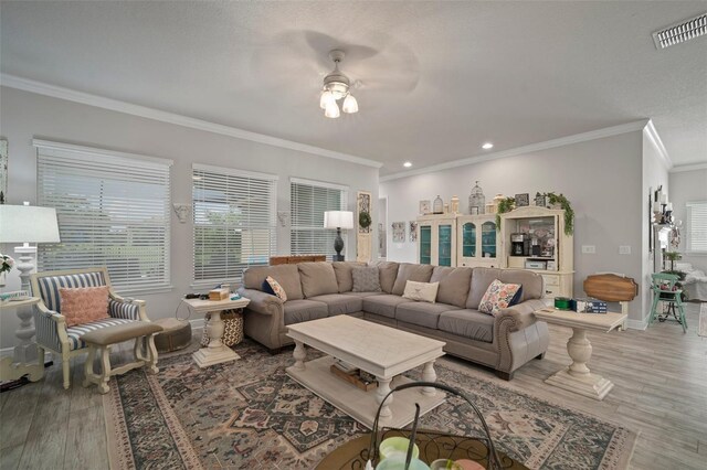 living room featuring hardwood / wood-style floors, ceiling fan, and ornamental molding