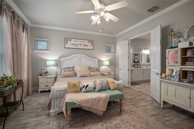 bedroom featuring light hardwood / wood-style floors, ensuite bath, ceiling fan, and ornamental molding