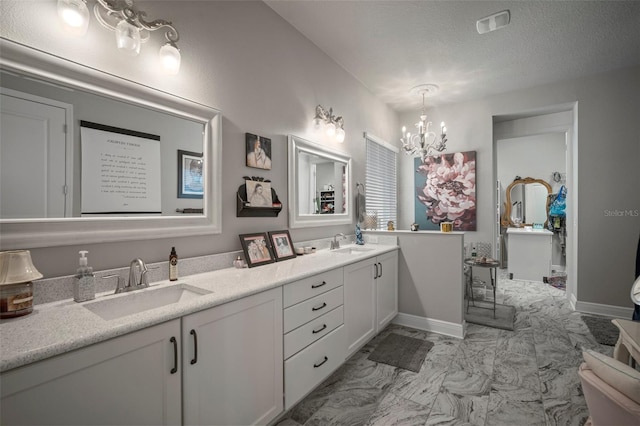 bathroom featuring vanity, a chandelier, and a textured ceiling