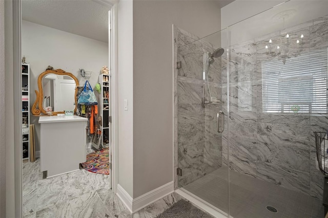 bathroom featuring a textured ceiling and a shower with door