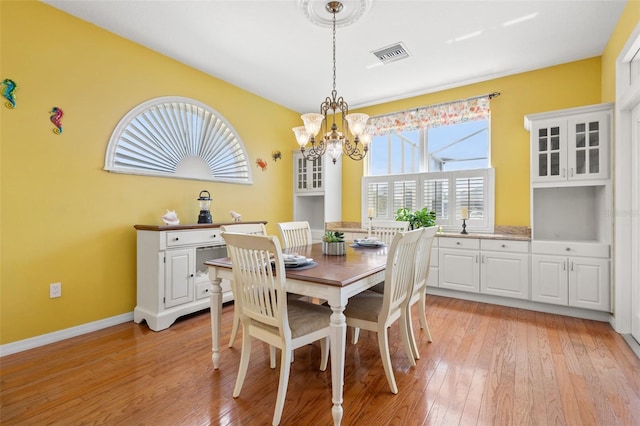 dining space featuring a chandelier and light wood-type flooring