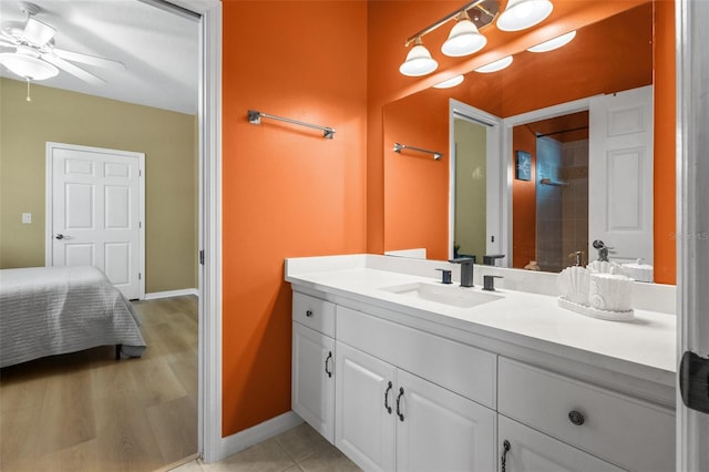 bathroom with ceiling fan, hardwood / wood-style floors, vanity, and tiled shower