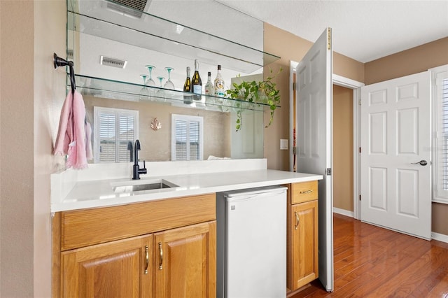 kitchen with sink, hardwood / wood-style flooring, and dishwasher