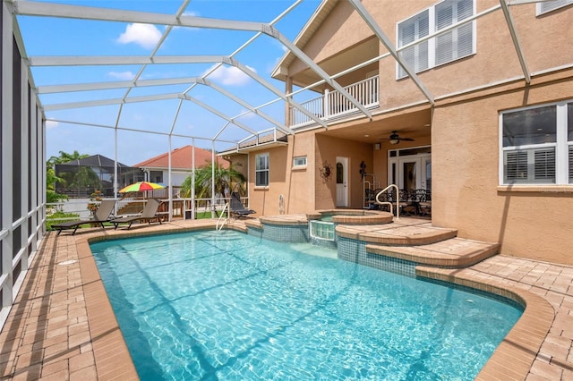 view of pool with glass enclosure, ceiling fan, and a patio area