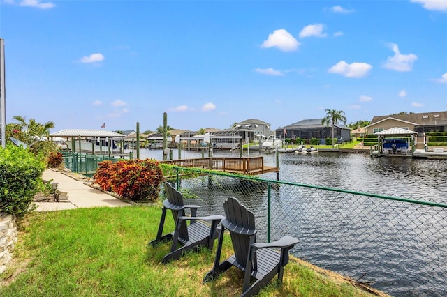 dock area with a lawn and a water view