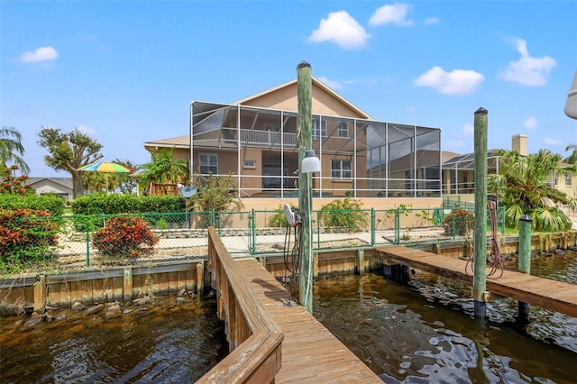 view of dock with glass enclosure and a water view