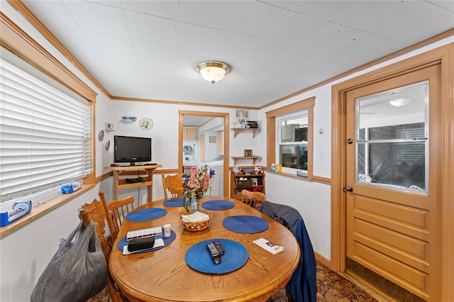 dining space featuring crown molding and a healthy amount of sunlight