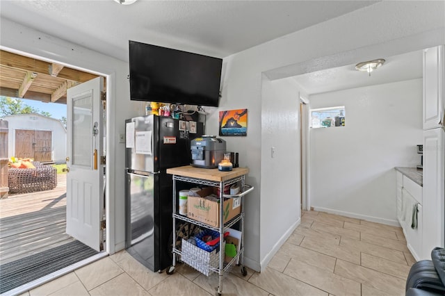 kitchen with white cabinets and black refrigerator