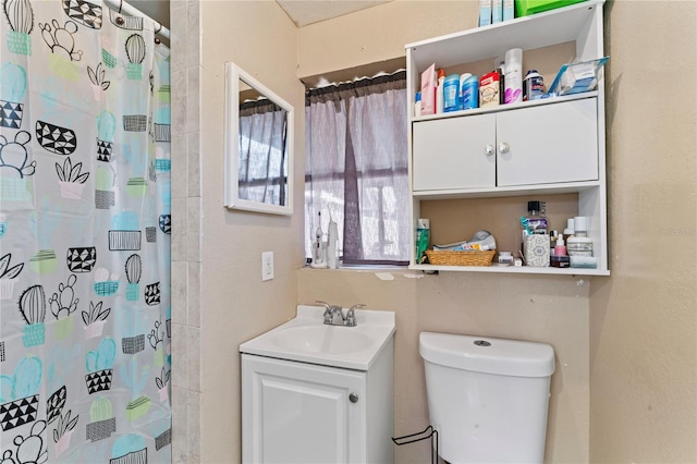 bathroom with vanity, toilet, and curtained shower