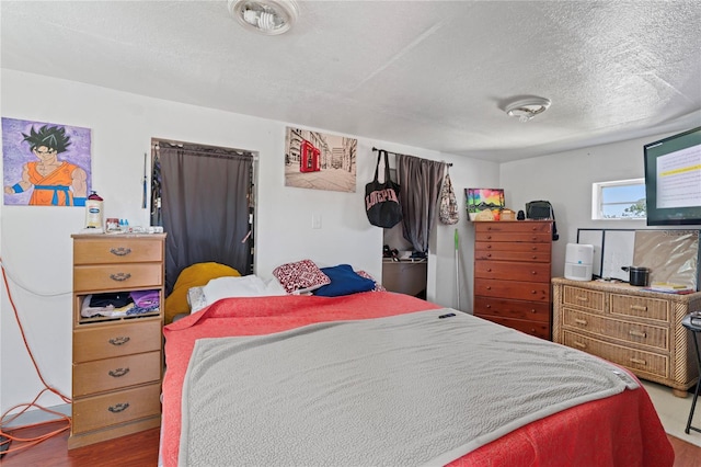 bedroom featuring wood-type flooring and a textured ceiling