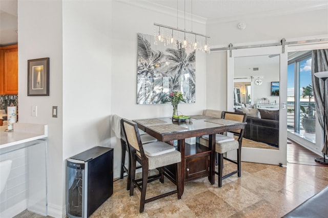 dining room with a barn door and crown molding