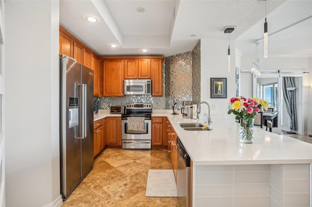 kitchen featuring pendant lighting, sink, decorative backsplash, appliances with stainless steel finishes, and kitchen peninsula