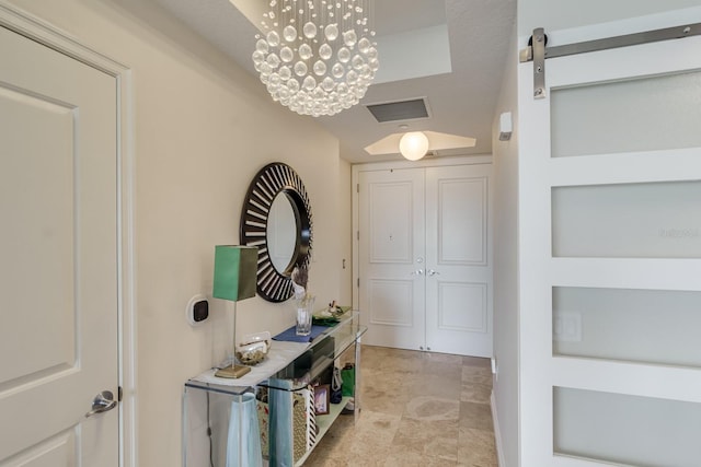 interior space with a barn door and a chandelier