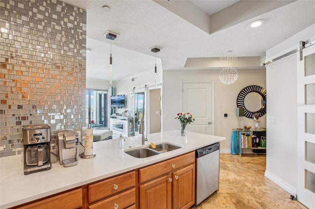 kitchen featuring a barn door, decorative light fixtures, stainless steel dishwasher, and sink