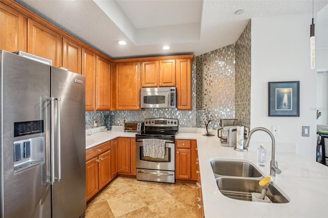 kitchen featuring decorative backsplash, a textured ceiling, stainless steel appliances, sink, and decorative light fixtures