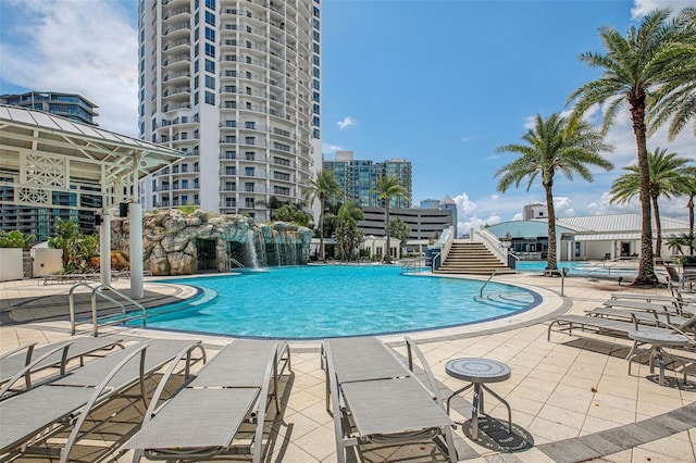 view of swimming pool with pool water feature and a patio