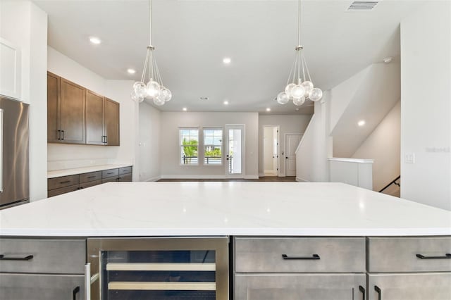 kitchen with wine cooler, a notable chandelier, visible vents, and a kitchen island