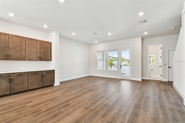 unfurnished living room with visible vents, recessed lighting, baseboards, and wood finished floors