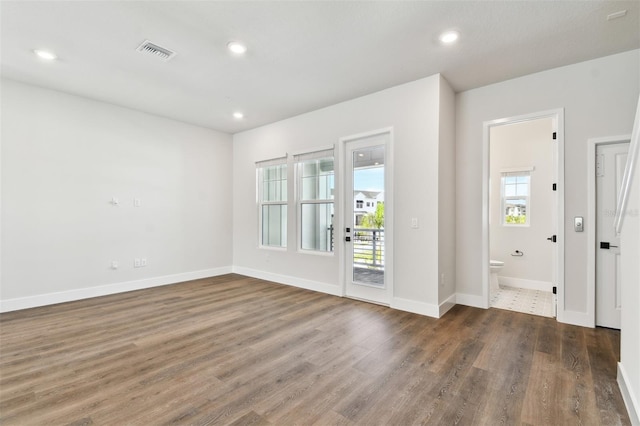 empty room with recessed lighting, visible vents, baseboards, and wood finished floors