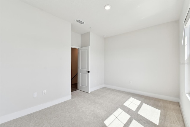 unfurnished bedroom featuring baseboards, visible vents, and light carpet