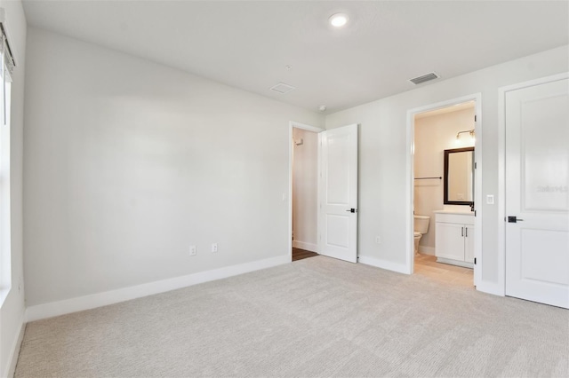 unfurnished bedroom featuring baseboards, visible vents, and light carpet