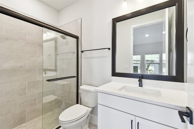 bathroom with vanity, toilet, and a shower stall