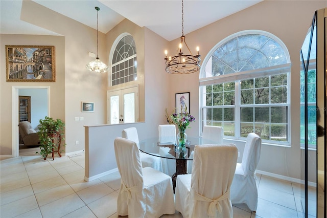 dining space with a notable chandelier, light tile patterned floors, and a high ceiling