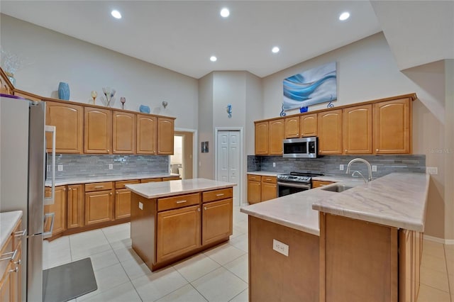 kitchen featuring stainless steel appliances, light tile patterned floors, a center island, tasteful backsplash, and sink