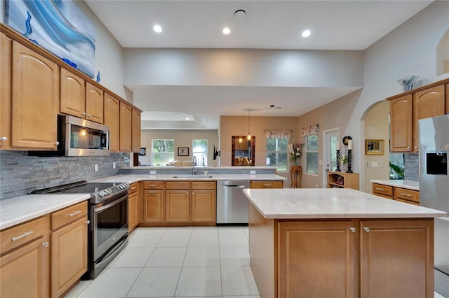 kitchen featuring sink, stainless steel appliances, kitchen peninsula, and a wealth of natural light