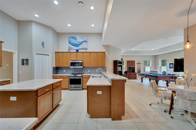 kitchen featuring decorative backsplash, appliances with stainless steel finishes, sink, billiards, and decorative light fixtures