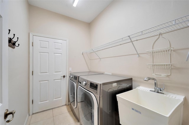 washroom with light tile patterned floors, sink, and washer and clothes dryer