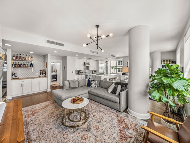 living room featuring hardwood / wood-style flooring, sink, and a notable chandelier