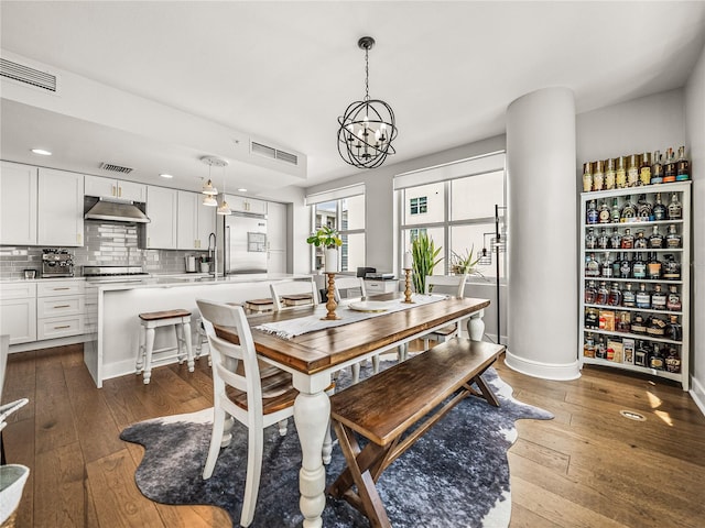 dining room with wood-type flooring and an inviting chandelier