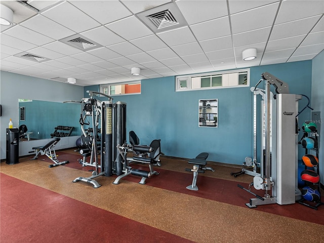 workout area with carpet floors and a drop ceiling