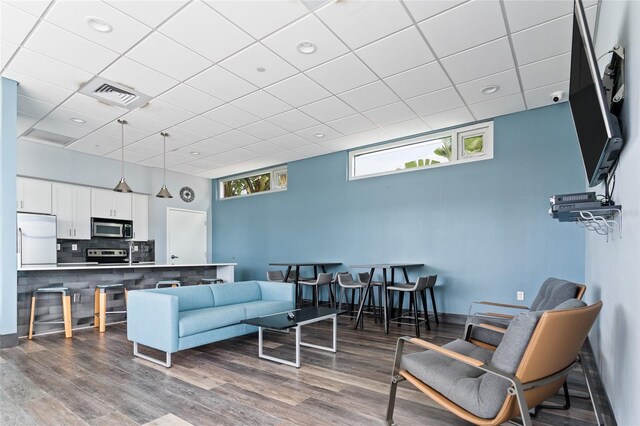 living room featuring hardwood / wood-style flooring and a paneled ceiling