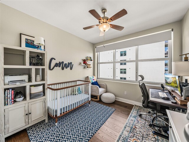 home office with ceiling fan and dark wood-type flooring