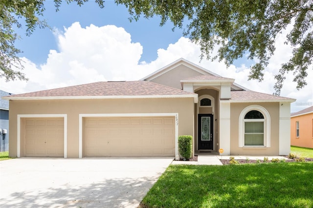 view of front of home featuring a front yard and a garage