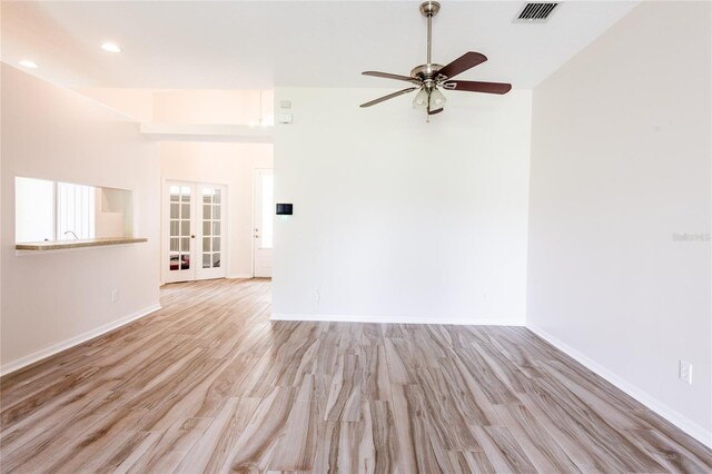 empty room with ceiling fan, french doors, and light hardwood / wood-style floors