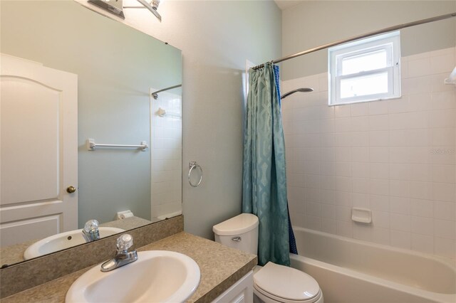 full bathroom featuring toilet, shower / bath combo with shower curtain, and vanity