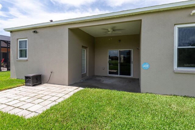 back of house featuring ceiling fan, a patio area, and a yard