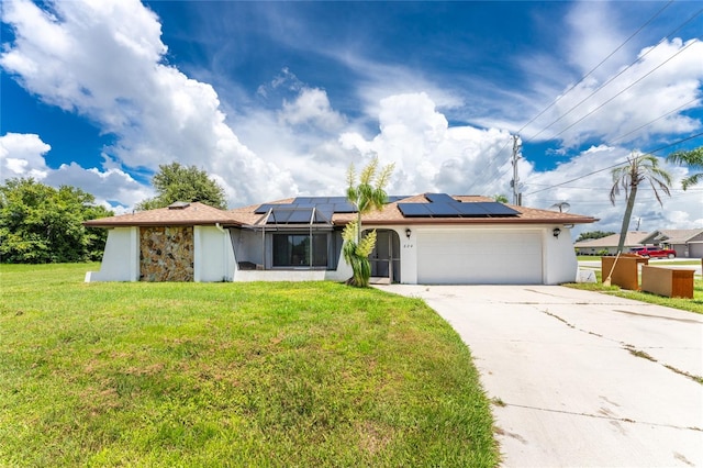 ranch-style home with a front lawn, solar panels, and a garage