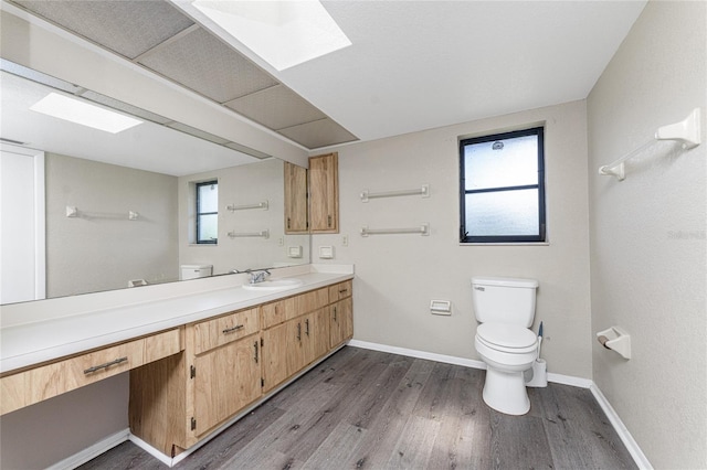 bathroom featuring vanity, a wealth of natural light, toilet, and hardwood / wood-style flooring